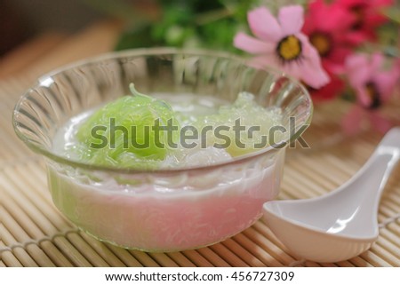 Sarim is a type of Thai dessert or chilled sweet vermicelli in coconut milk. It in a glass cup on wooden background.