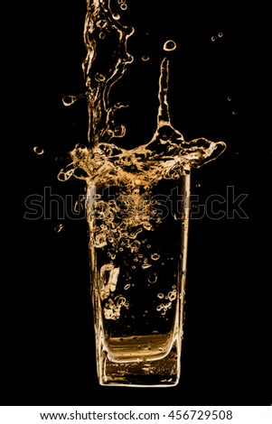 Splash out drink from glass on a black background.
