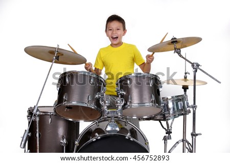 Happy young boy playing drums Royalty-Free Stock Photo #456752893