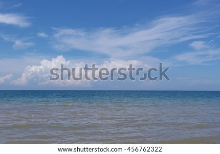 White clouds and blue sky above the sea at noon