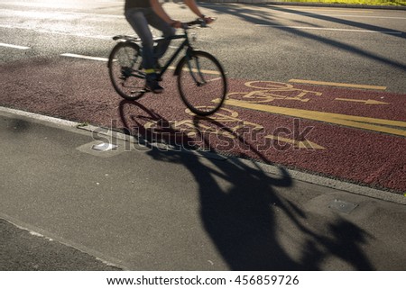 Sustainable city transportation: Bikers commuting to the work, riding fast in a cycling line on the street (motion blurred image)