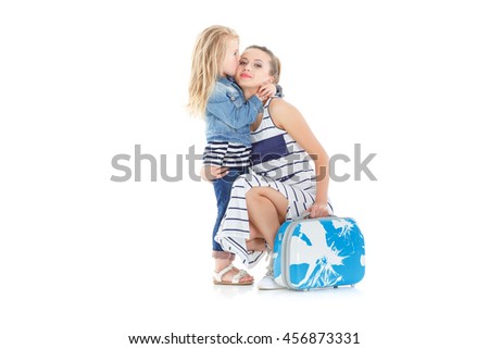  daughter kisses beautiful young mother. woman and child with a suitcase on white background