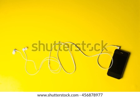 cell phone, headphone, pockets on yellow background