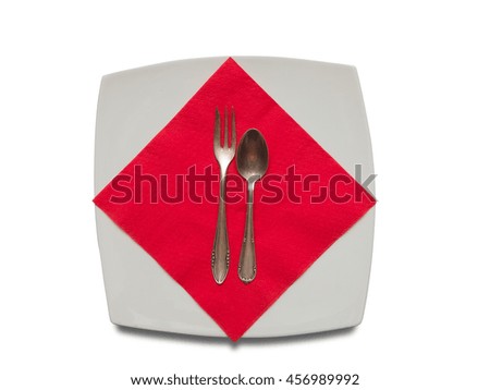 Empty white plate, spoon, fork and red napkin over white background