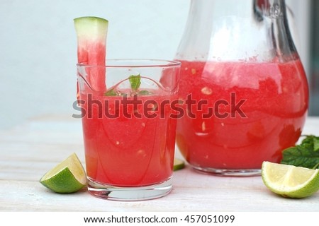 Healthy fresh smoothie drink from red watermelon and ice drift in glass with straw, front horizontal view