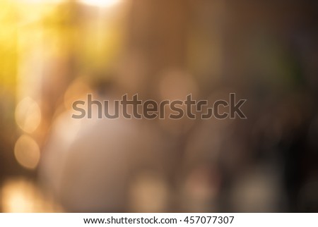 People walking down the street in the evening, beautiful light at sunset. The photo is purposely made out of focus, no faces are recognisible