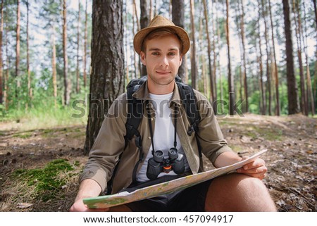 Happy male tourist looking for direction