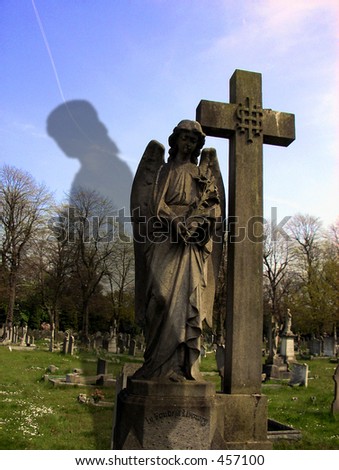 This is a grave in the shape of a  angel with a ghost in the picture..