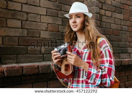 Outdoor summer smiling lifestyle portrait of pretty young woman having fun in the city with camera travel photo of photographer
