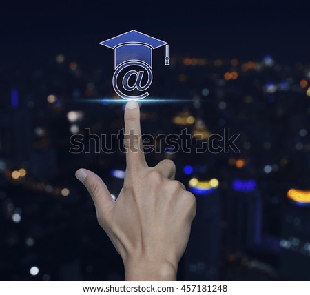 Hand pressing e-learning icon over blur light city tower background, Study online concept
