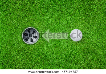 Abstract  golf ball and golf hole on green grass texture background with direction symbol.