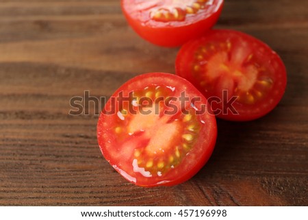 Red tomato slices on wooden background