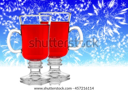 Two glasses of mulled wine on blue winter background, close up