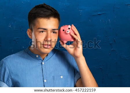 young man holding a piggy bank