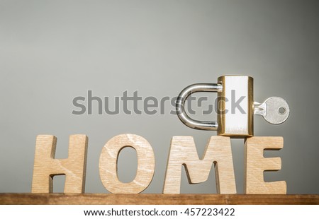wooden word made from letters with metal lock and key stand on wood table isolated on gray background 