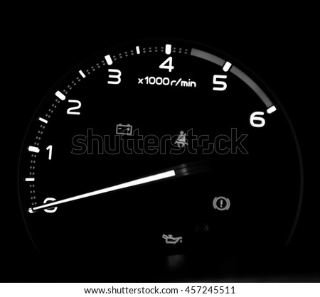 rpm gauge and caution symbol in car at night time on black background with copy space. automotive part concept.