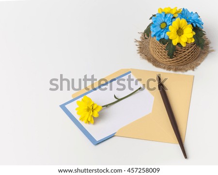 Blank card, envelope and flowers on wood background