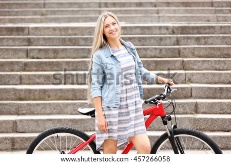 Beautiful girl with bike on street