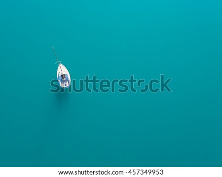 Beautiful aerial view of alone yacht sailing on azure water