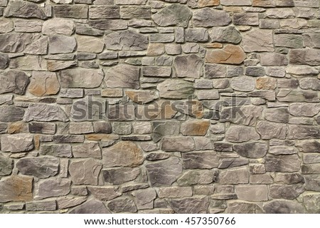 Modern Textured Grey Yellow Stonewall Made From Flagstone And Sandstone Slabs Background, Bumpy Stone Wall Texture, Rocky Structure Backdrop Royalty-Free Stock Photo #457350766
