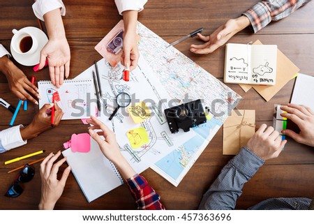 Picture of businessmen's hands on wooden table with documents and drafts