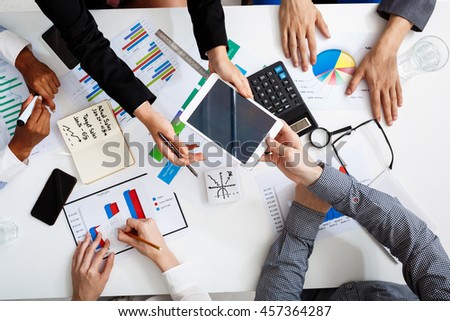 Picture of businessmen's hands on white table with documents and drafts