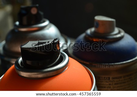 Fluorescent Orange Spray Paint Can and Dark Blue Spray Paint Can Royalty-Free Stock Photo #457365559