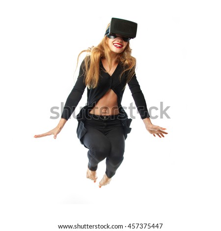 cheerful young woman in virtual reality helmet isolated on white background jumping and smiling. VR glasses. Third dimension. Virtual reality helmet.