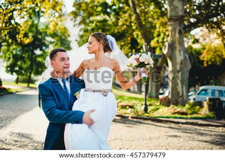 groom holds his wife on his hands