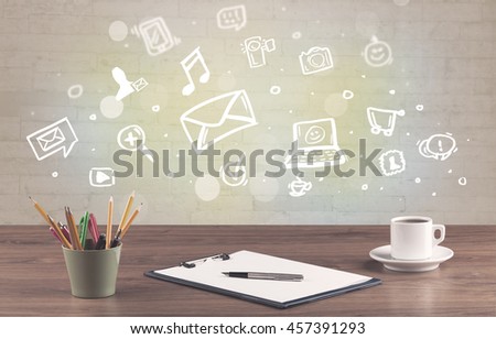 Social media online communication concept with icons and close up of business office desk full of work equipement