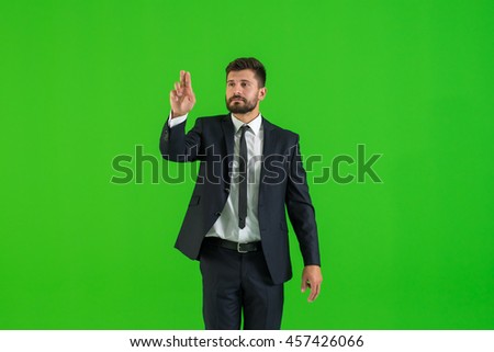 The businessman touch the virtual screen on the green background