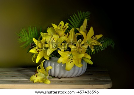 Bouquet of yellow lilies in a vase .
