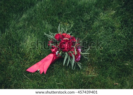 beautiful wedding bouquet of vinous color on the grass with flowers, roses,peonies. Space for text