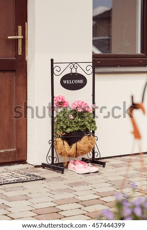 Flower Arrangement with Welcome Greeting on Metal Plate near the Door