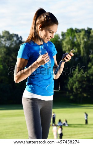 Young women reading sms message on her smartphone in the park