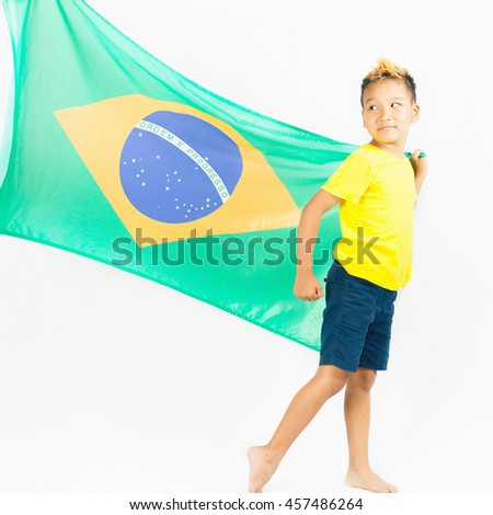Brazilian patriot boy walking and holding Brazil flag. Football or soccer championship. Support fan. White background