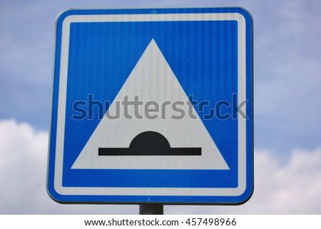 Speed bump road sign against blue sky