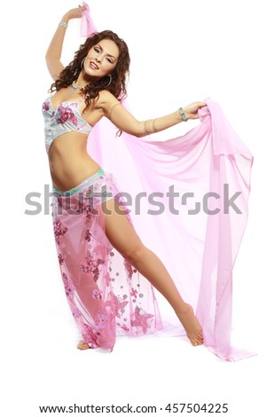 Beautiful Arabic belly dancer harem woman in black with silver dressdancing arms in air, isolated on white