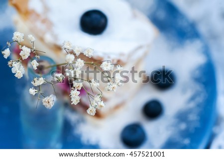 white flowers and sweet cakes with berries on background. picture with soft focus