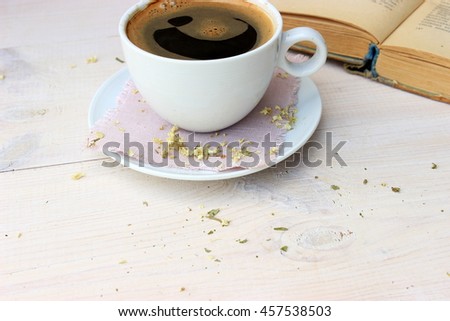 Full light composition with cup of fresh tasty coffee, vintage book with yellow shabby cover and paper and ///. Concept for beautiful romantic morning theme with retro decor elements