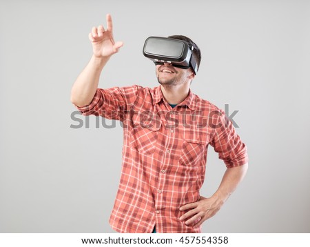 Man with virtual reality glasses showing gesture isolated on a gray background