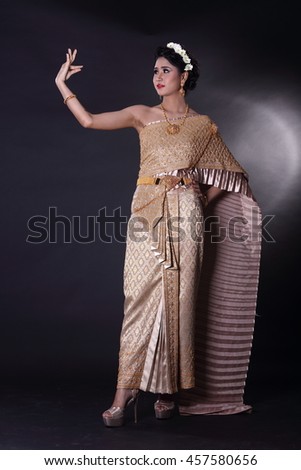 Asian woman wearing traditional antique Thai dress. Studio lighting with dark background.