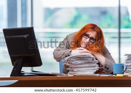 Stressed businesswoman with stack of papers