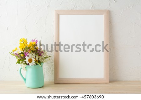 Frame mockup with tender flowers in mint green vase. Poster white frame mockup. Empty white frame mockup for presentation design.