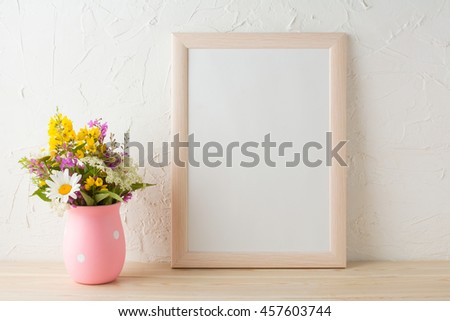 Frame mockup with wild flowers in pink vase. Portrait or poster white frame mockup. Empty white frame mockup for presentation artwork.