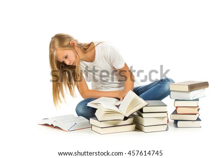 Young girl sitting on the floor with books reading over white background