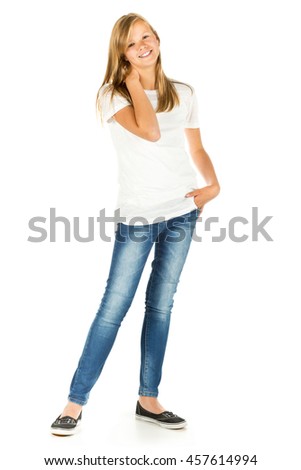 Young girl standing smiling with white t-shirt and blue jeans over white background