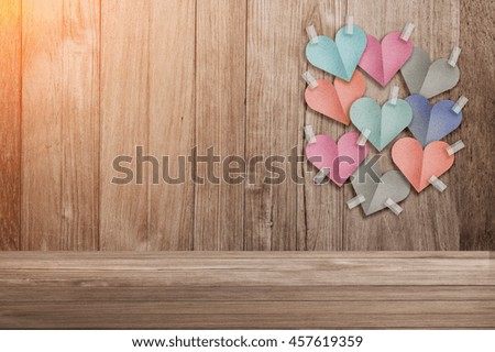 colorful heart shape paper cut stick on old wooden background with copy space and light flare effect