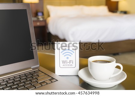 Hotel room with wifi access sign, laptop and cup of coffee Royalty-Free Stock Photo #457634998