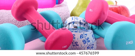 Health and fitness concept with pink and blue dumbbells and accessories on a pink wood table, sized to fit a popular social media cover image placeholder.